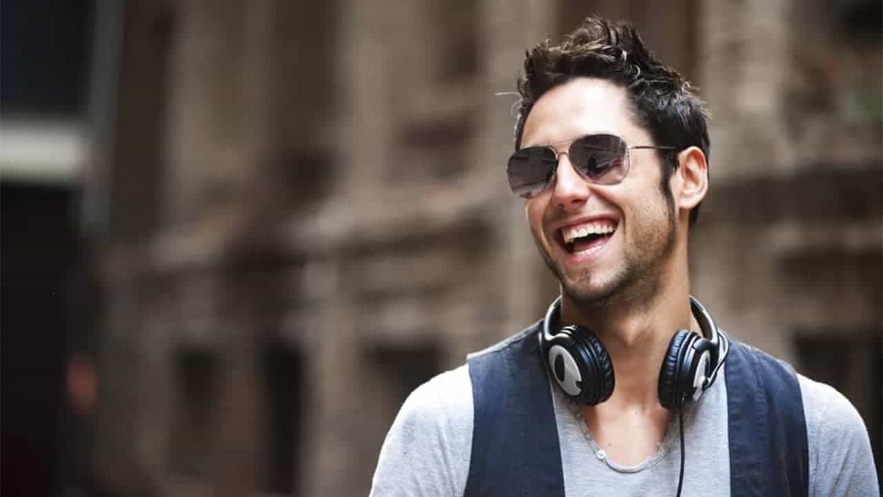 Un jeune homme souriant après avoir été admis à la formation proposée par DJ Network.