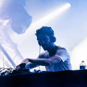 Un DJ Producteur en pleine prestation sur scène lors d'un festival, illustrant son expertise dans le cadre d'une formation professionnelle.