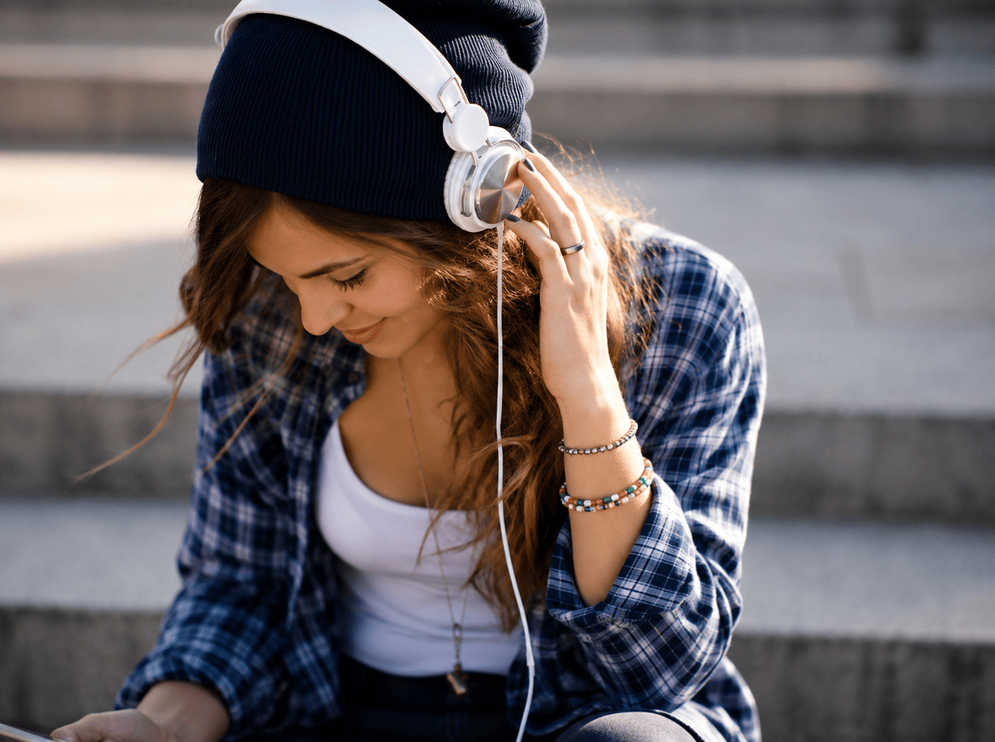 Une jeune femme souriante, réalisant son entretien de positionnement en visioconférence sur son téléphone portable pour son admission chez DJ Network.